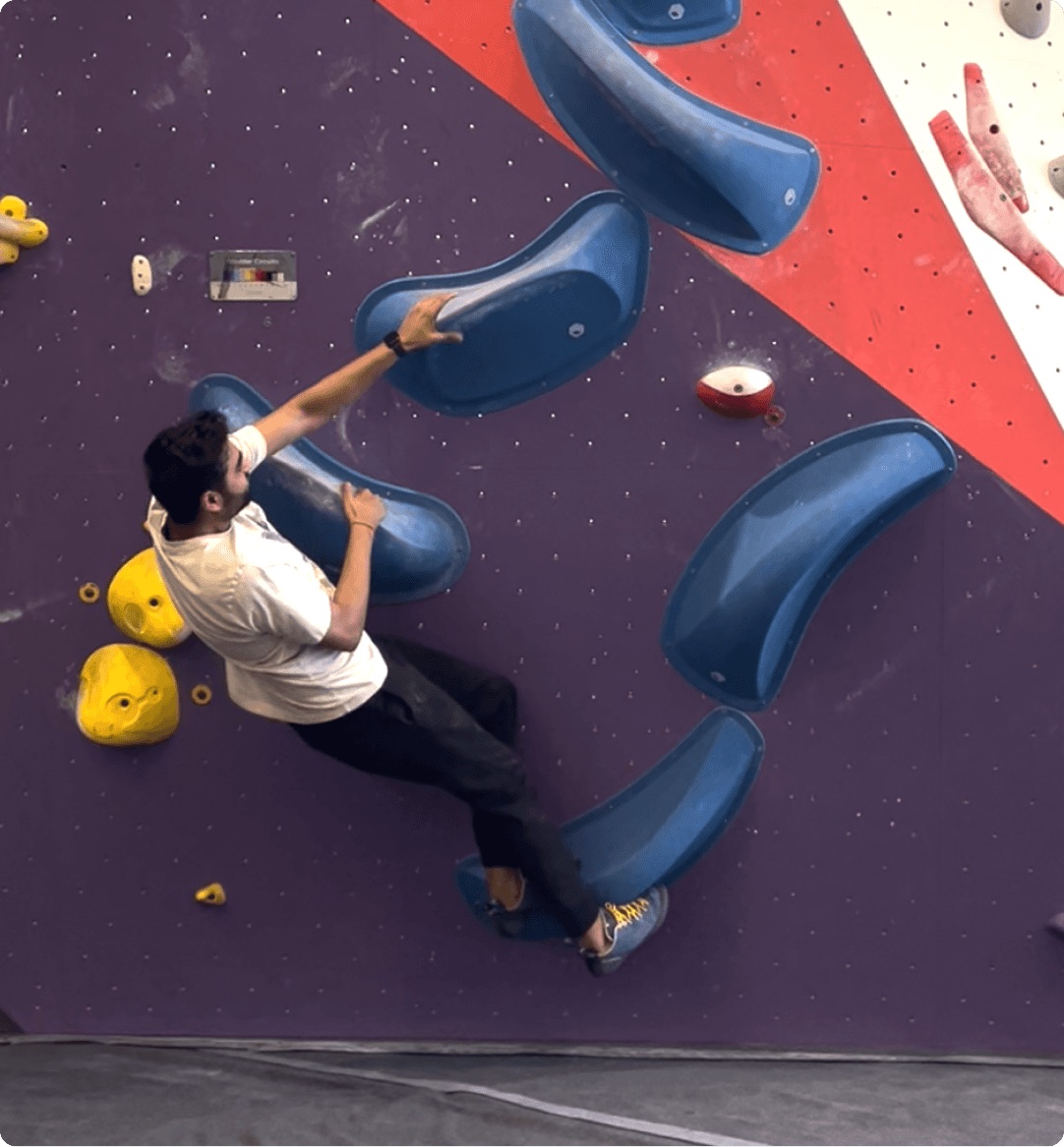 Parimal working through a route on a bouldering wall