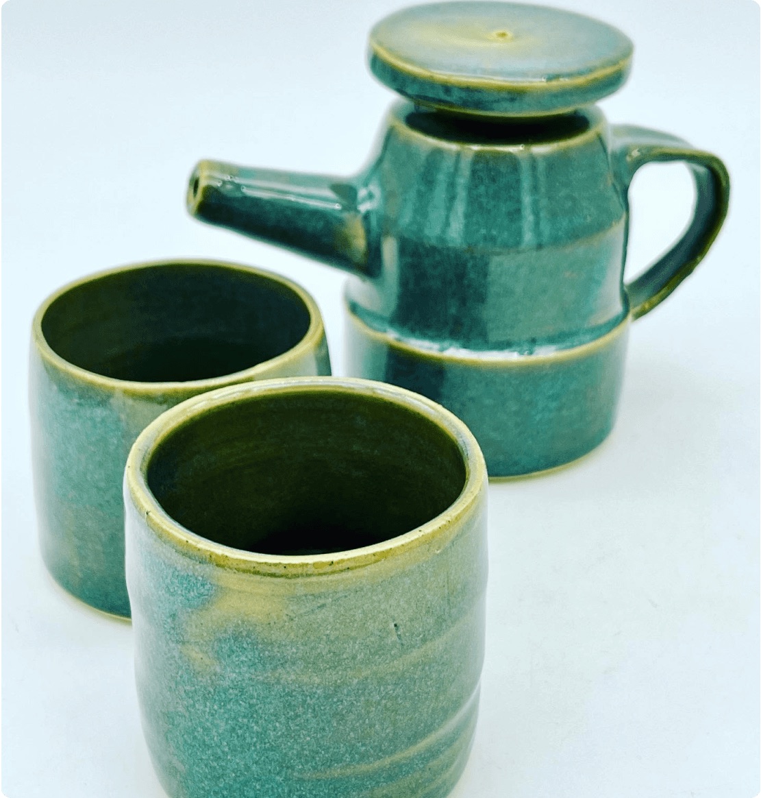Green ceramic cups and a lidded pot made by Parimal